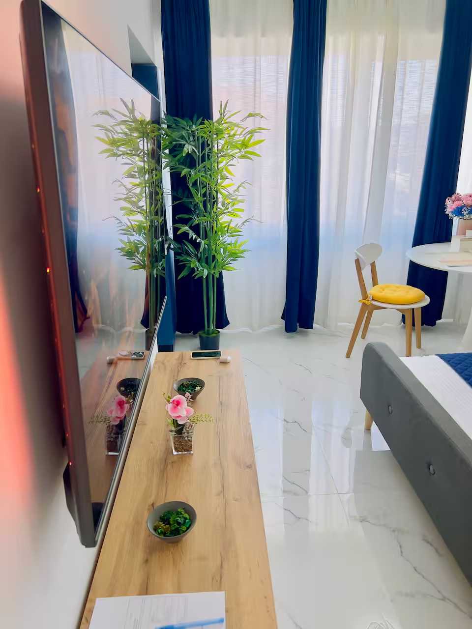 A room with a bed, a table, a chair, a pot plant and a TV — studio in Pitesti