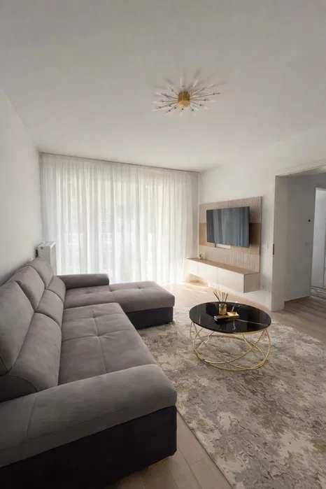 A living room with a couch and a flat-screen TV — apartment in Brașov