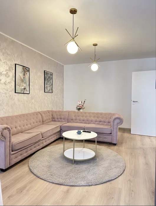 A living room with a sofa, a coffee table, and a lamp — apartment in Brașov