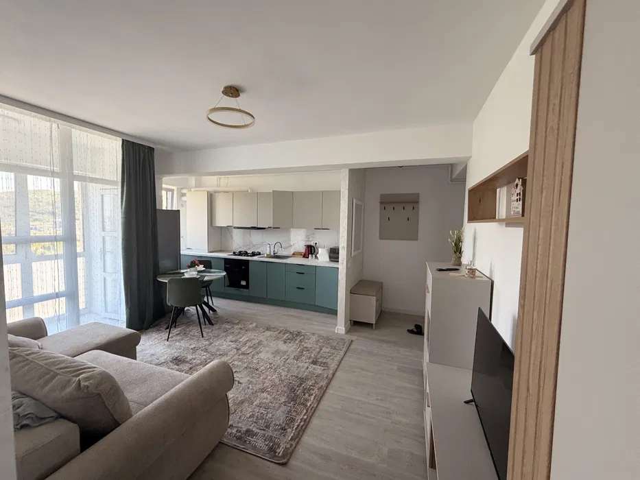 A living room with sofa, chair and window