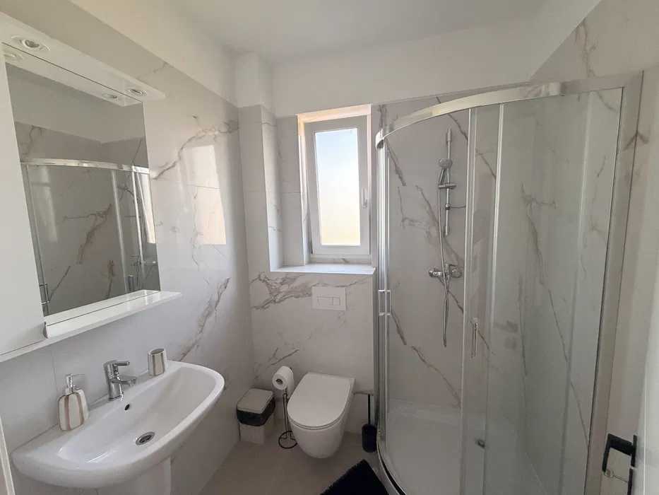 A bathroom with toilet, laundry and shower