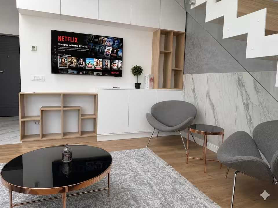 A living room with a flat screen TV and a window — apartment in Oradea