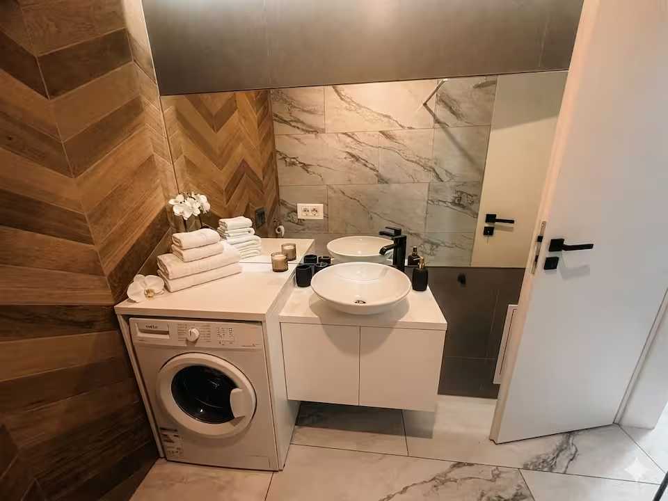 A bathroom with a white dishwasher, a washing machine and a mirror — apartment in Oradea