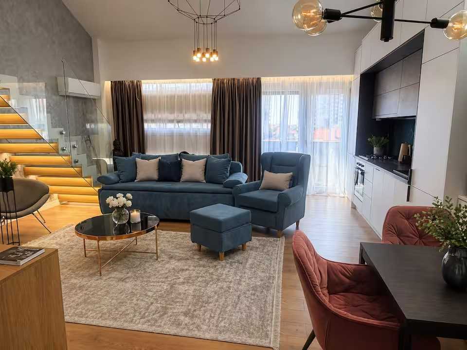 A living room with a blue sofa and a chair — apartment in Oradea