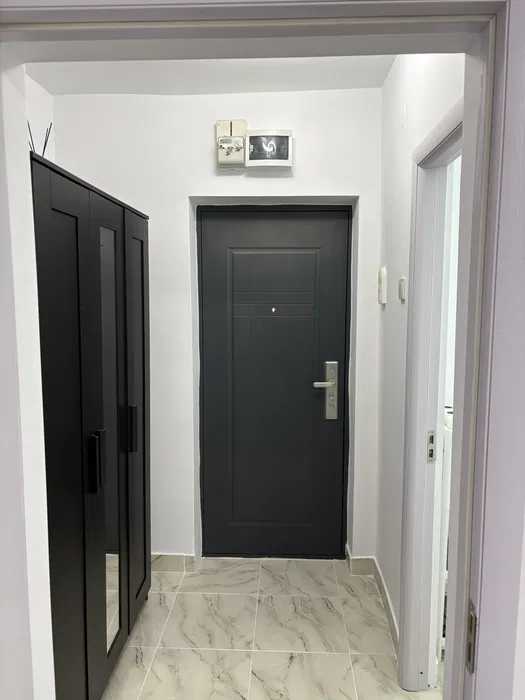 A dark room with a door and window