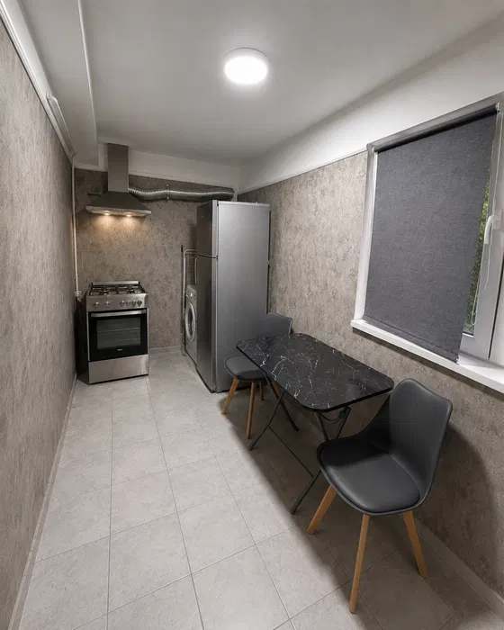 A small kitchen with table and chairs