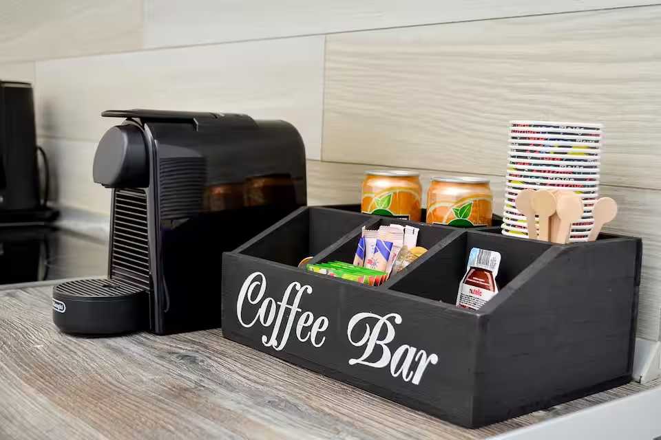 A black coffee bar with a coffee machine and coffee boxes — studio in Oradea