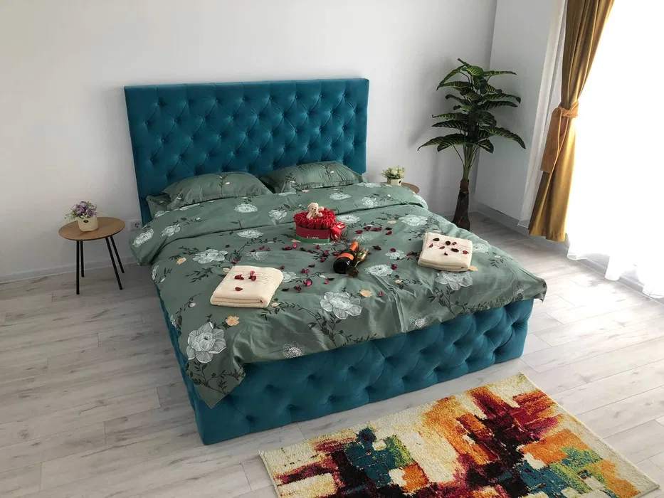 A room with a blue bed and a window — studio in Brașov