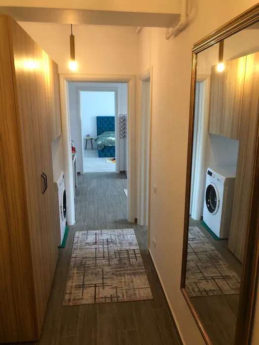 A small, white room with a bed and a washer-dryer — studio in Brașov