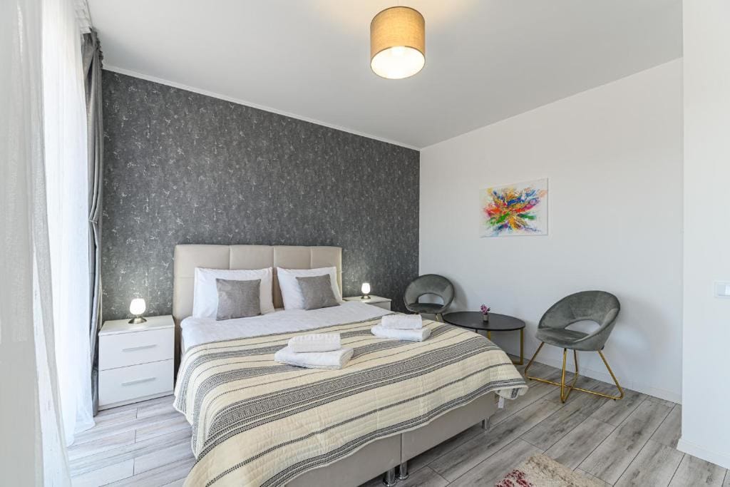 A room with a bed, a chair and a lamp — apartment in Brașov