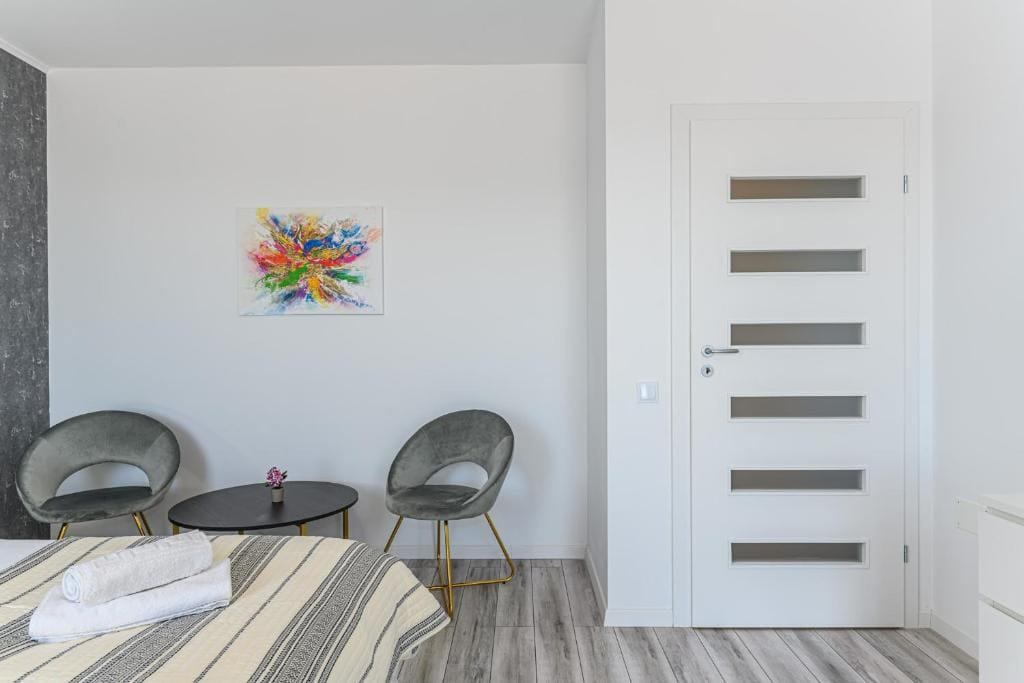 A room with a bed, a chair and a painting on the wall — apartment in Brașov