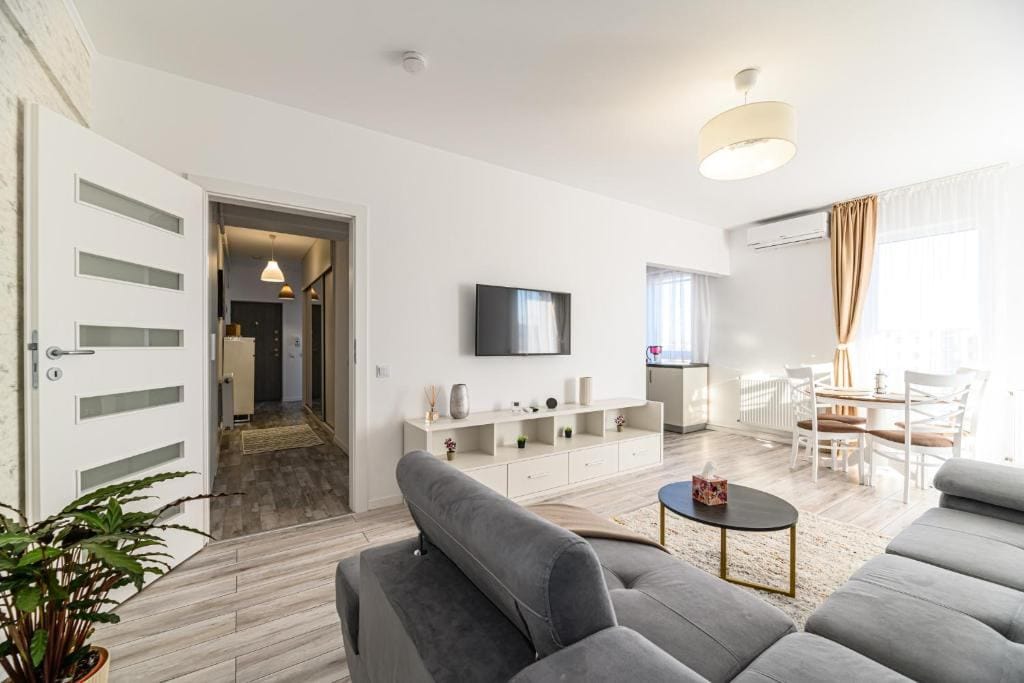 A living room with a sofa, a flat-screen TV and a fireplace — apartment in Brașov