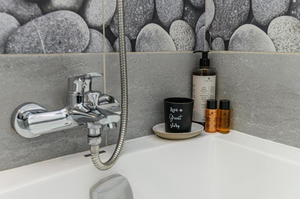 A bath with shower and a cup — apartment in Brașov