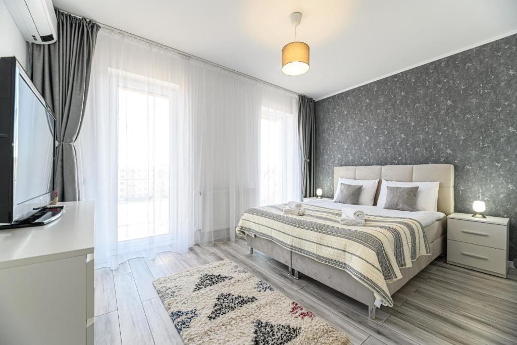 A room with a bed, a lamp and a window — apartment in Brașov