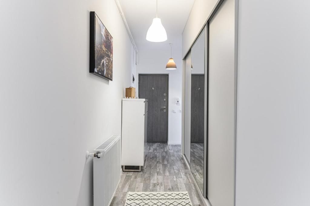 A small room with a white door and a mirror — apartment in Brașov