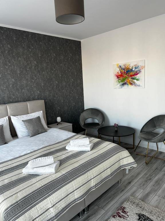 A room with a bed, a chair and a picture on the wall — apartment in Brașov