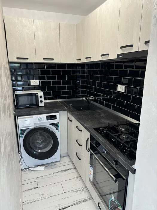 A small kitchen with a top oven and laundry dryer