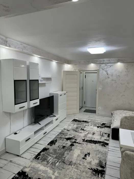 A living room with a flat screen TV and a carpet