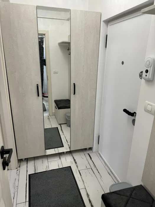 A small, white room with mirror and toilet