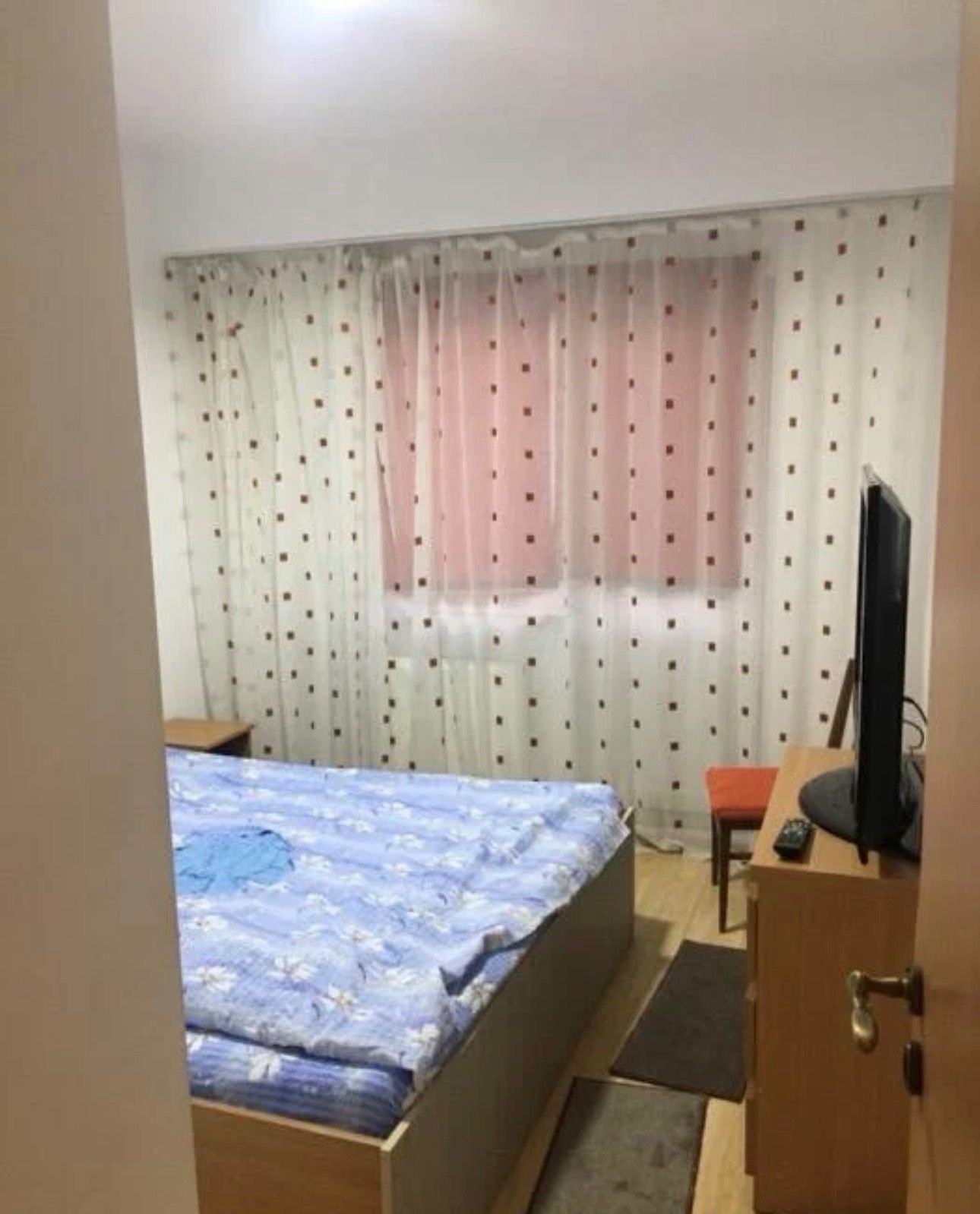 A room with a bed, a chair and a TV