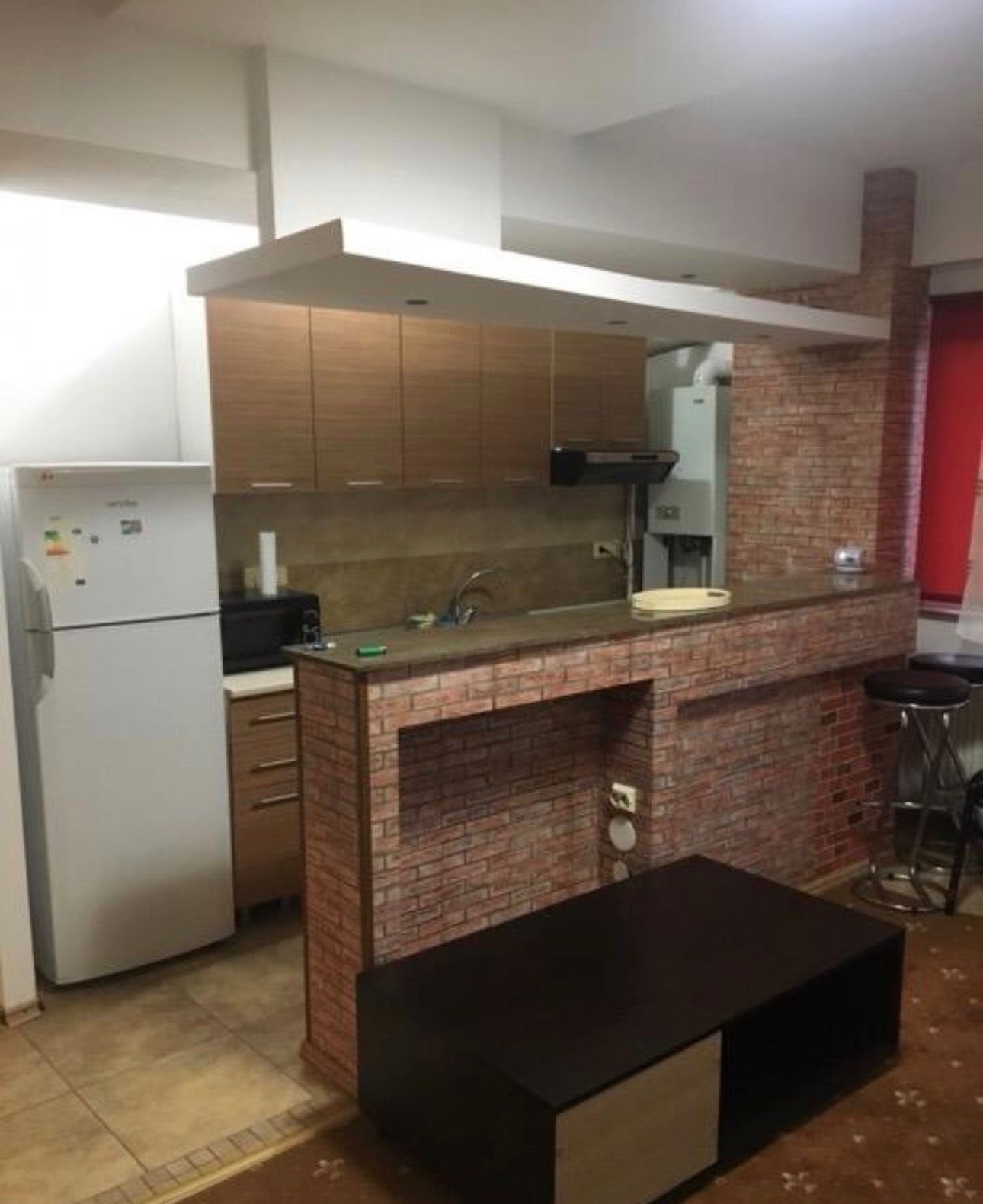 A small kitchen with a brick wall and a table