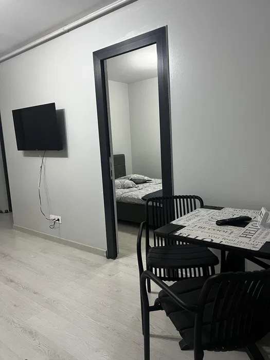 A small room with a bed, a table and a TV