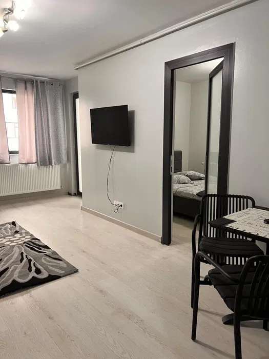 A room with a bed, a TV and a mirror