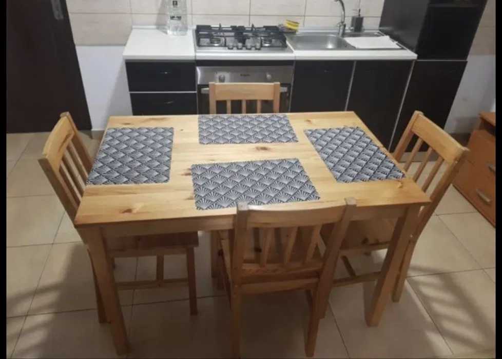 A kitchen with a wooden table and chairs
