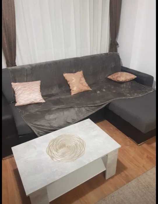 A living room with sofa, table and window