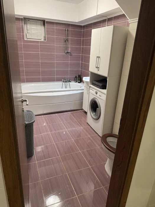 A bathroom with toilet and a washing machine
