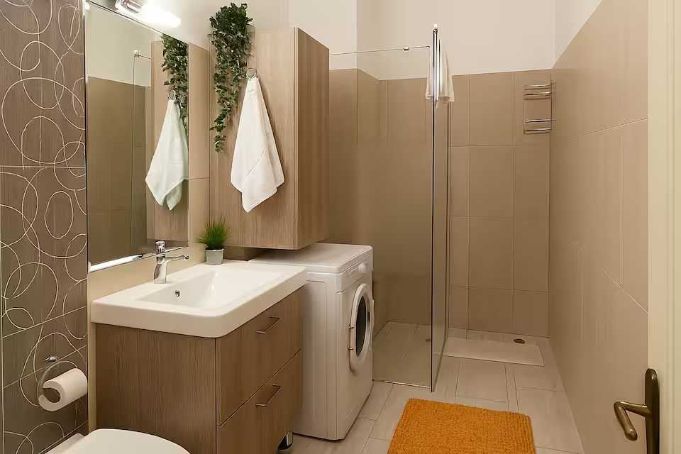 A small bathroom with dishwasher and a washing and drying machine — apartment in Oradea