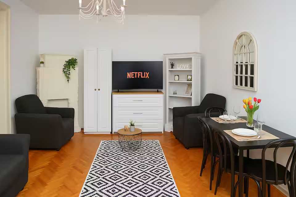 A living room with a black sofa and a white closet — apartment in Oradea