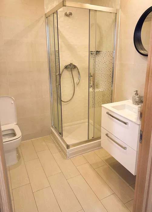 A bathroom with a toilet, sink, and shower — apartment in Bucuresti