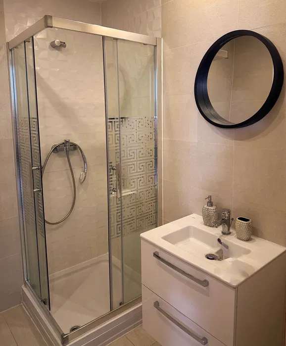 A bathroom with a shower and a sink — apartment in Bucuresti