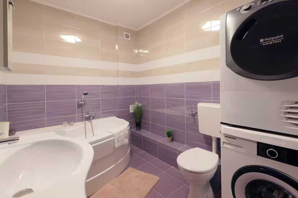 A bathroom with toilet, dishwasher and sofa — apartment in Oradea