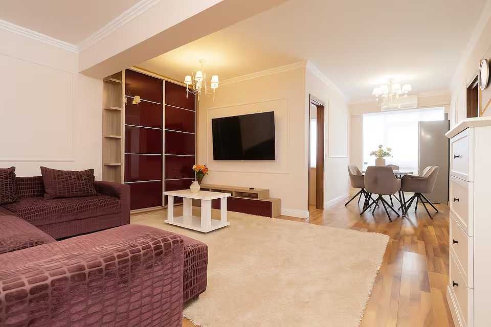 A living room with sofa, chair and TV — apartment in Oradea
