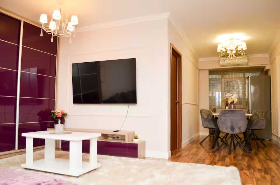 A living room with a flat screen TV and a table — apartment in Oradea