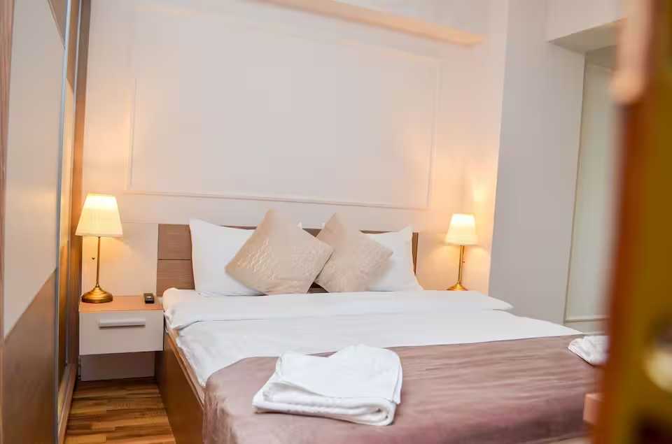 A room with a bed and a lamp — apartment in Oradea