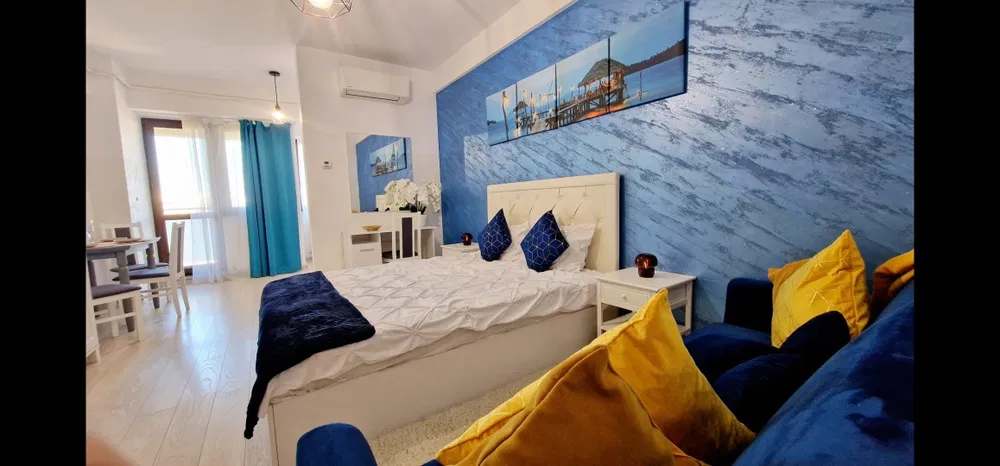 A room with a bed, a chair and a painting on the wall