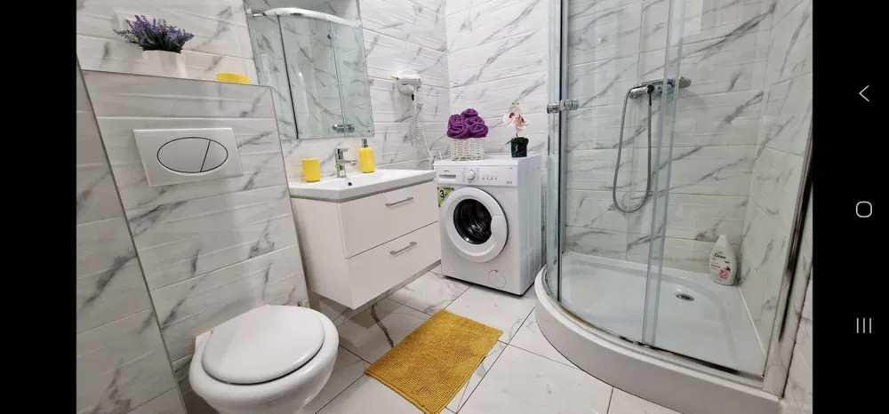A bathroom with toilet, dishwasher and washing machine